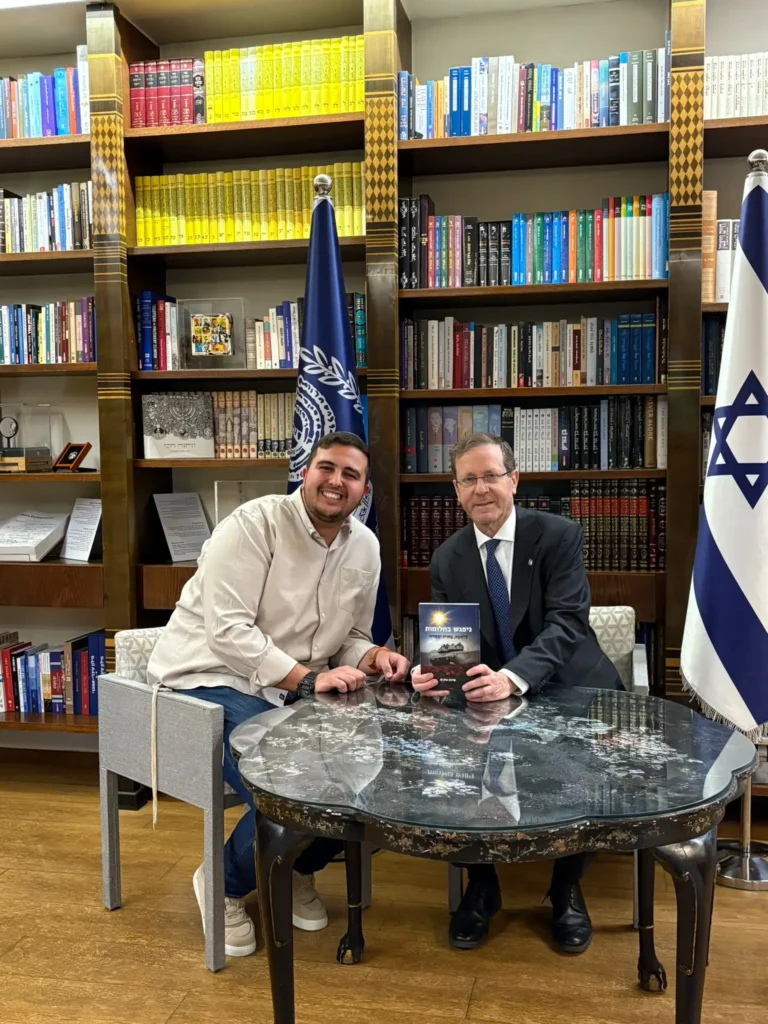 נשיא המדינה יצחק הרצוג מעיין בספר "ניפגש בחלומות" ולצידו יושב מחבר הספר, שילה אלג'ם.